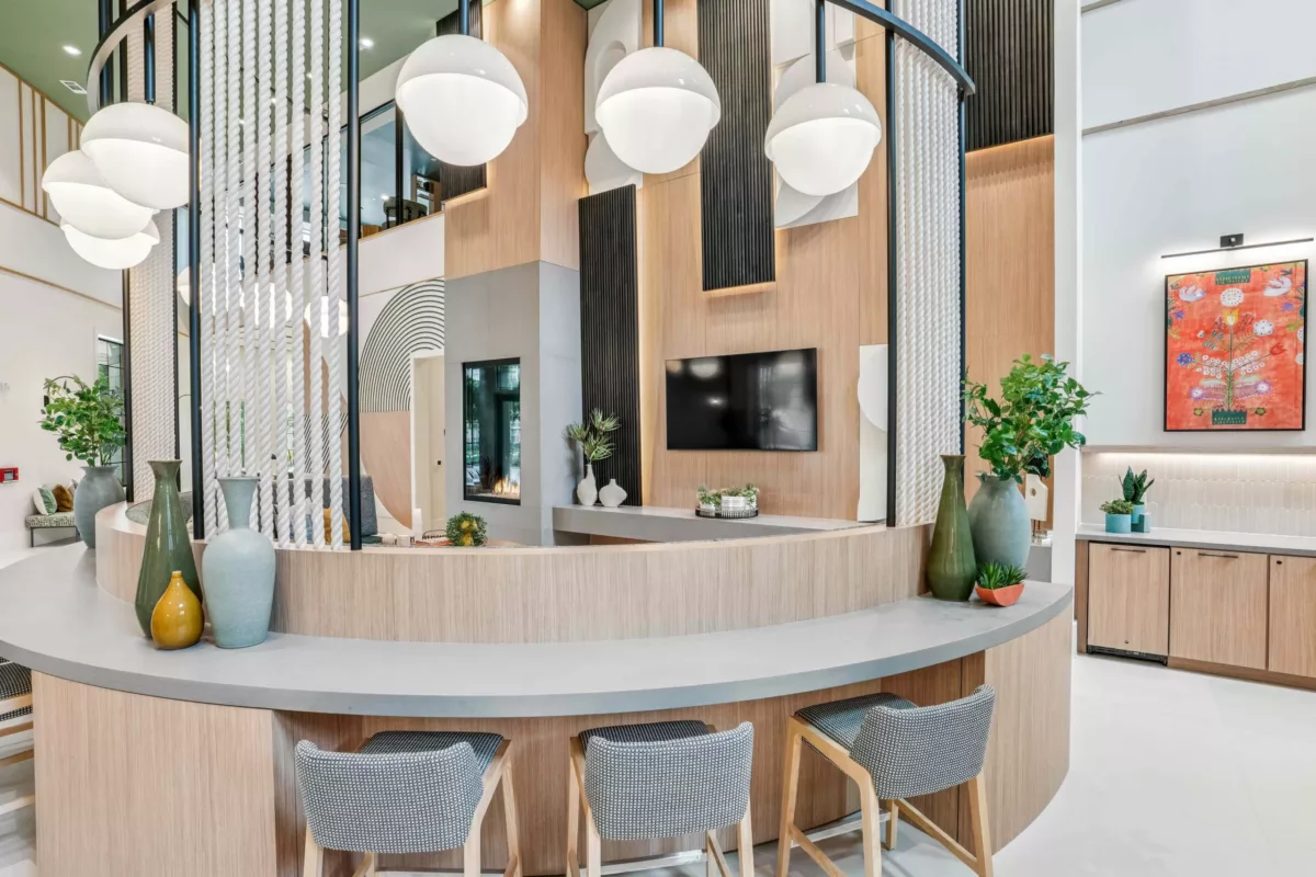 Clubroom with curved bar, stools, decorative vases, a TV, and a fireplace.