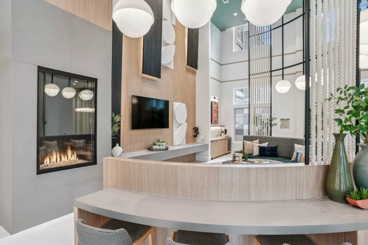 Clubroom with fireplace, TV, seating, and high ceilings with globe pendant lights.